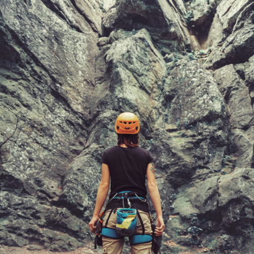 Femme devant une falaise s'apprêtant à grimper